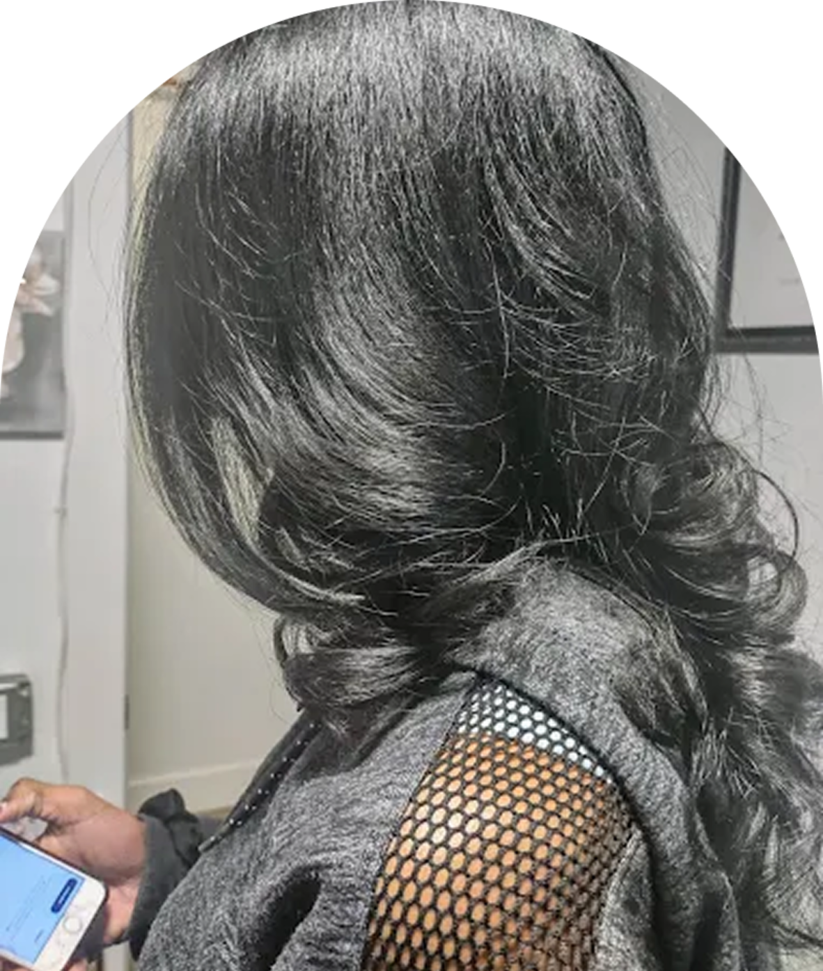 Person with long black hair holding phone.
