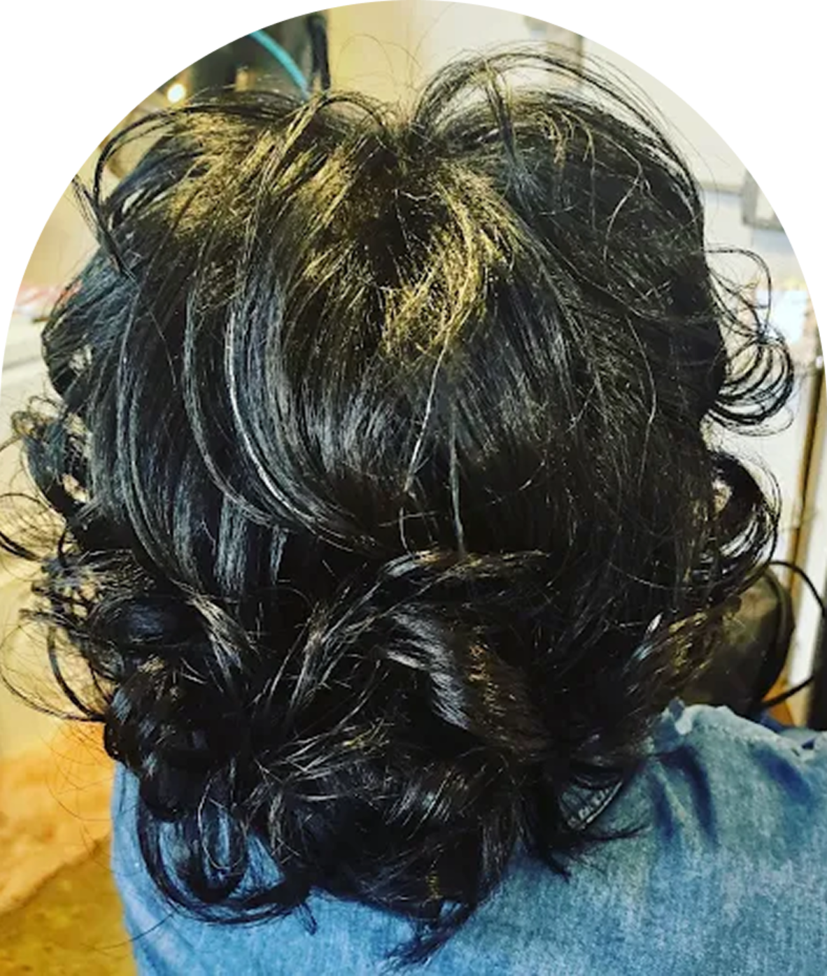 Curly, dark hair from the back view.